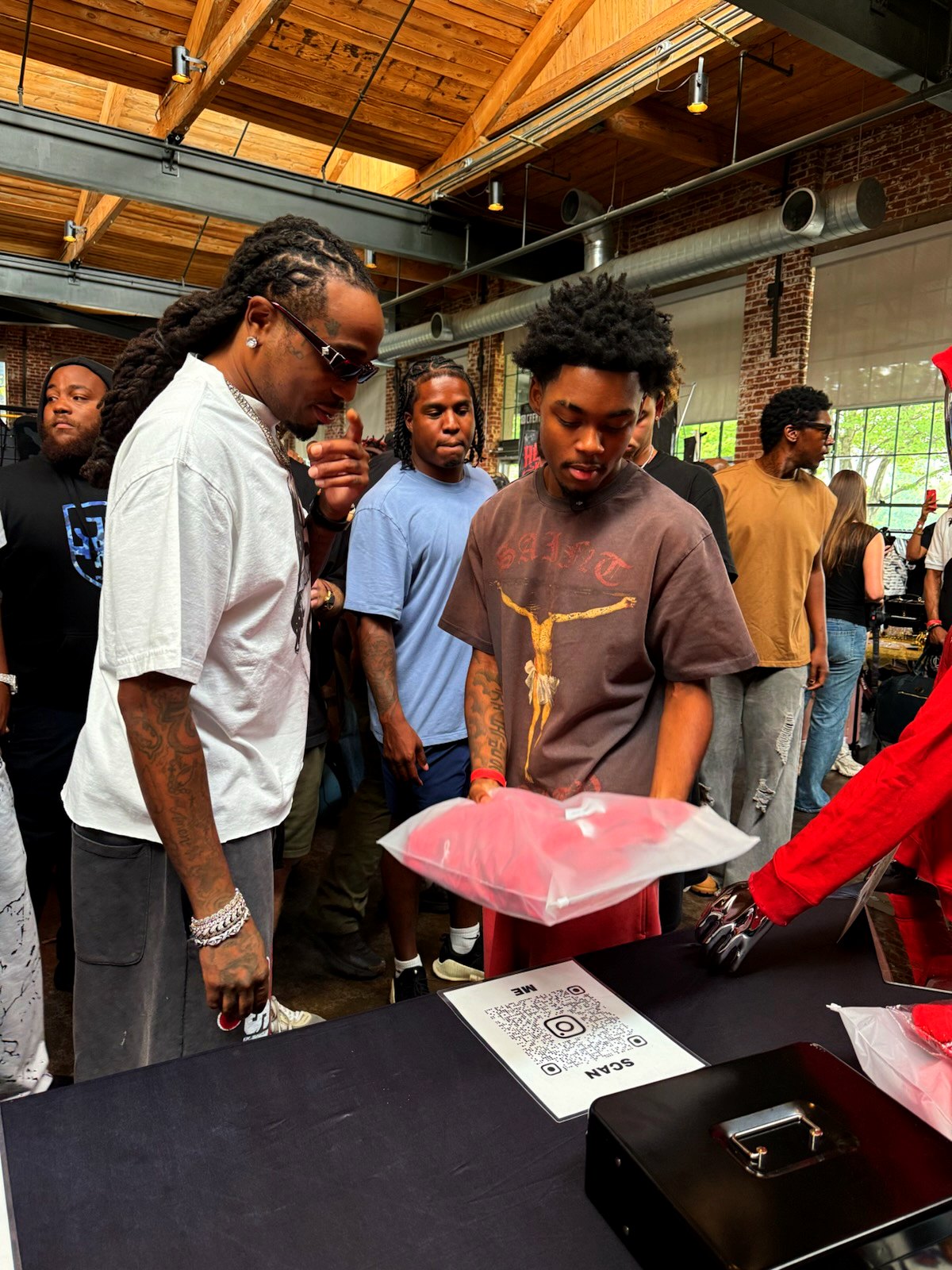 Shoppers looking at a red YARE piece at the YARE table during the Unfazed Streetwear Market